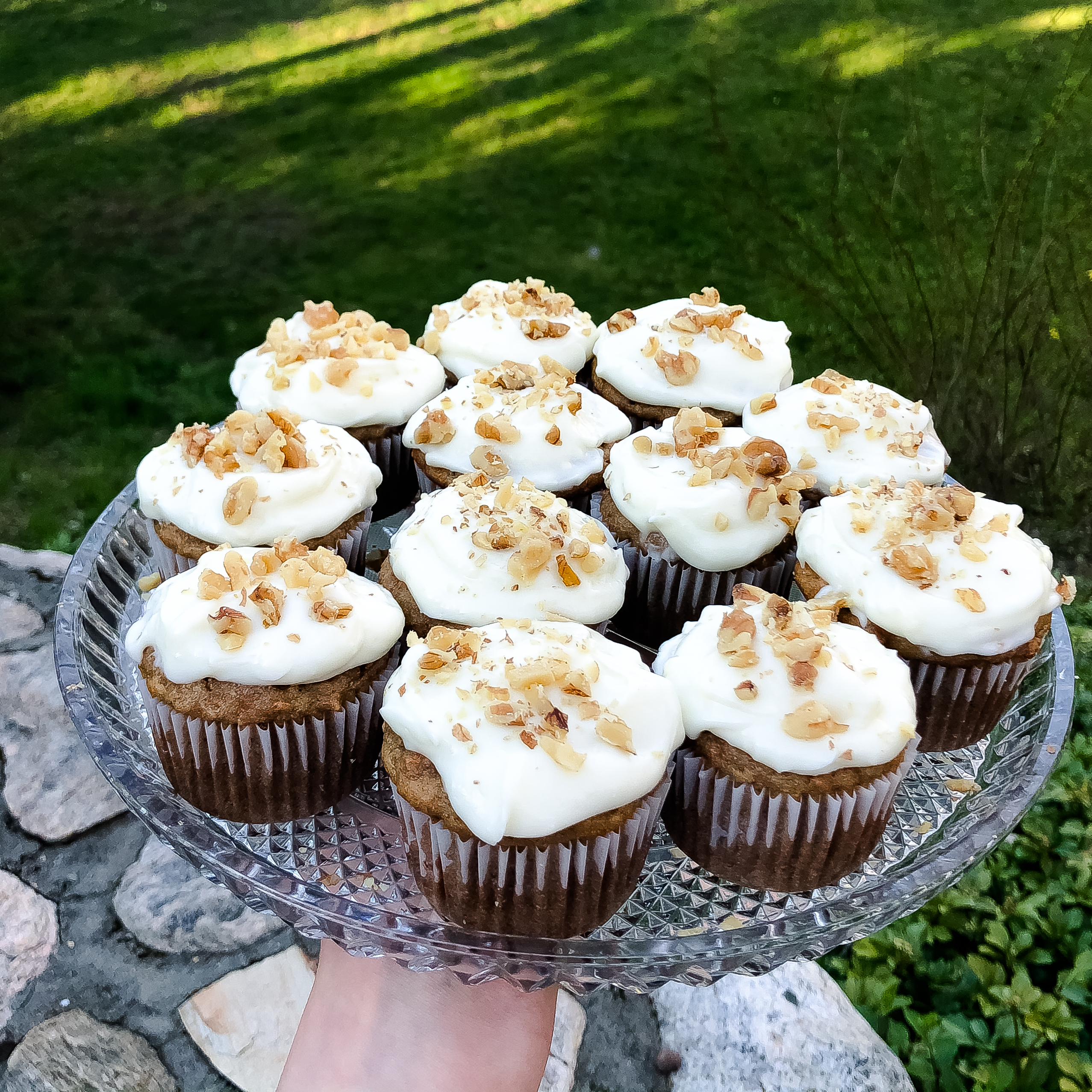 Finished plate of easy gluten free carrot cake cupcakes with cream cheese frosting with chopped walnuts on top