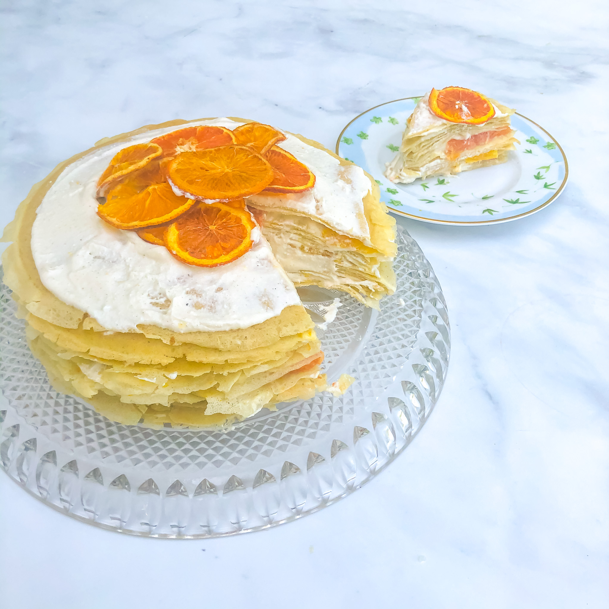 Finished cake and a slice of the summer citrus crepe cake with whipped ricotta and cardamom filling