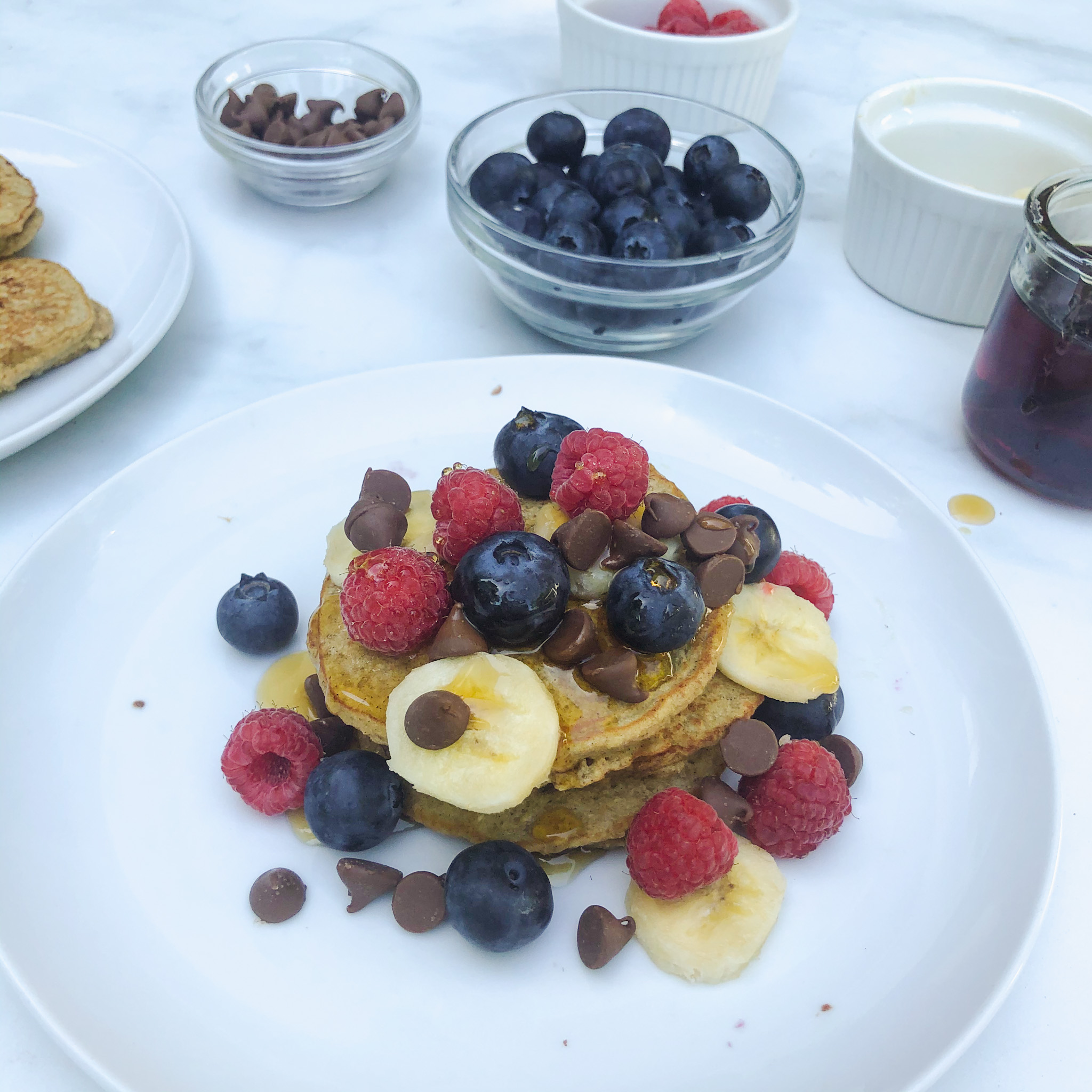 Finished plate of easy and healthy gluten free banana chocolate chip pancakes with fruit