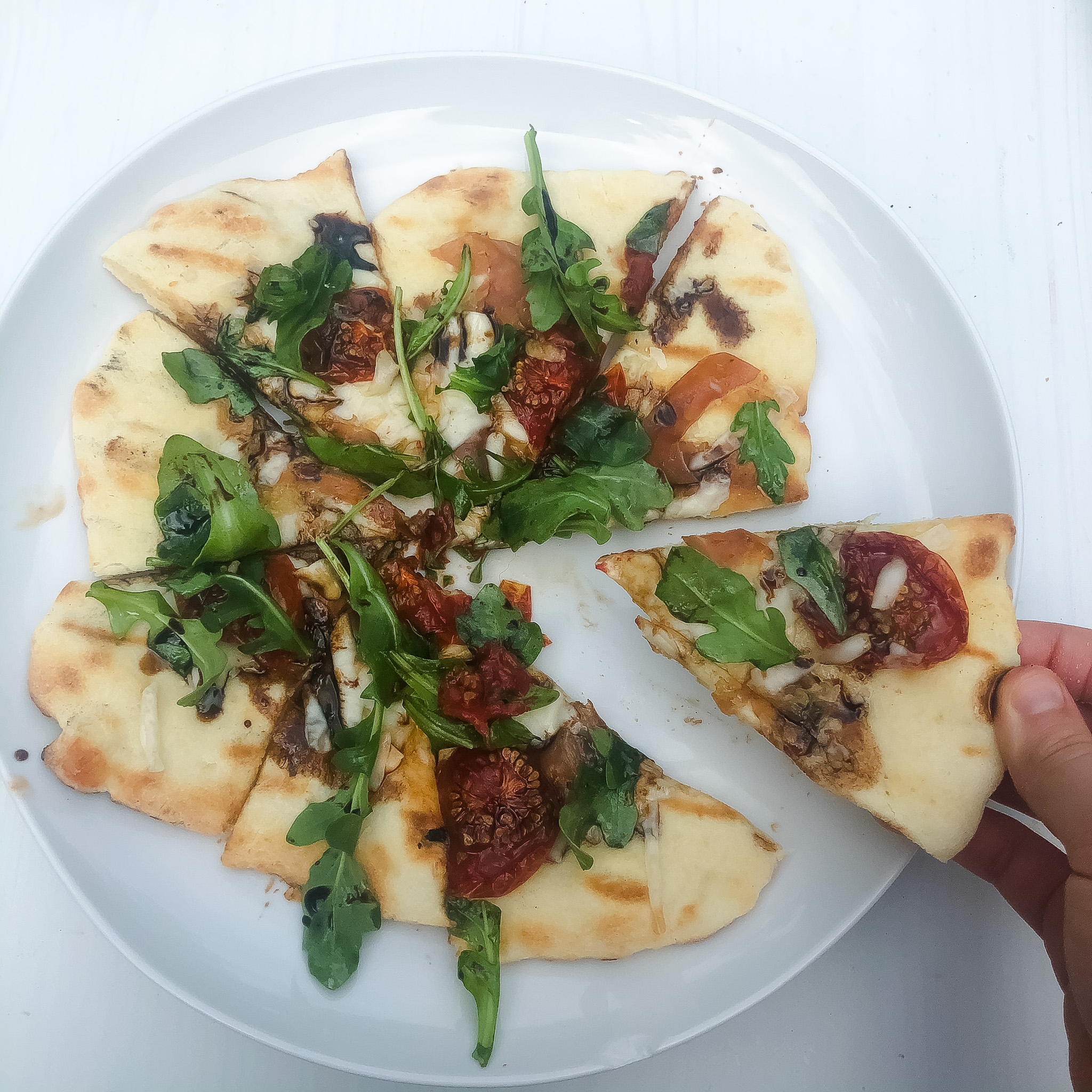 finished gluten free grilled flatbread with arugula and roasted tomatoes