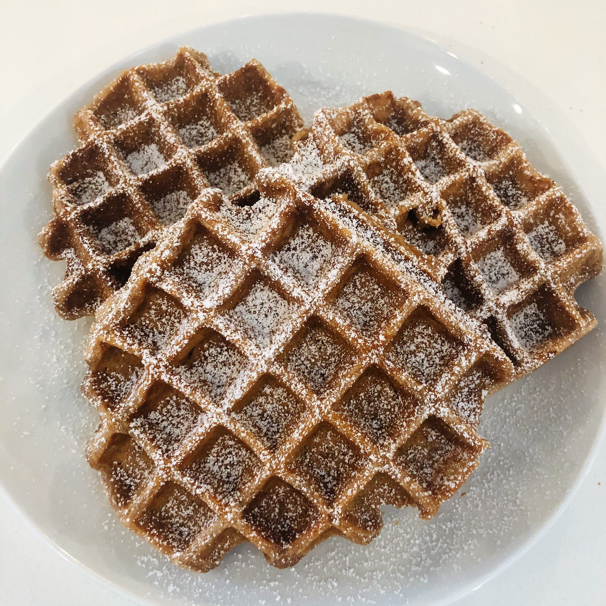 the finished gluten free chocolate belgian waffles dusted with powdered sugar